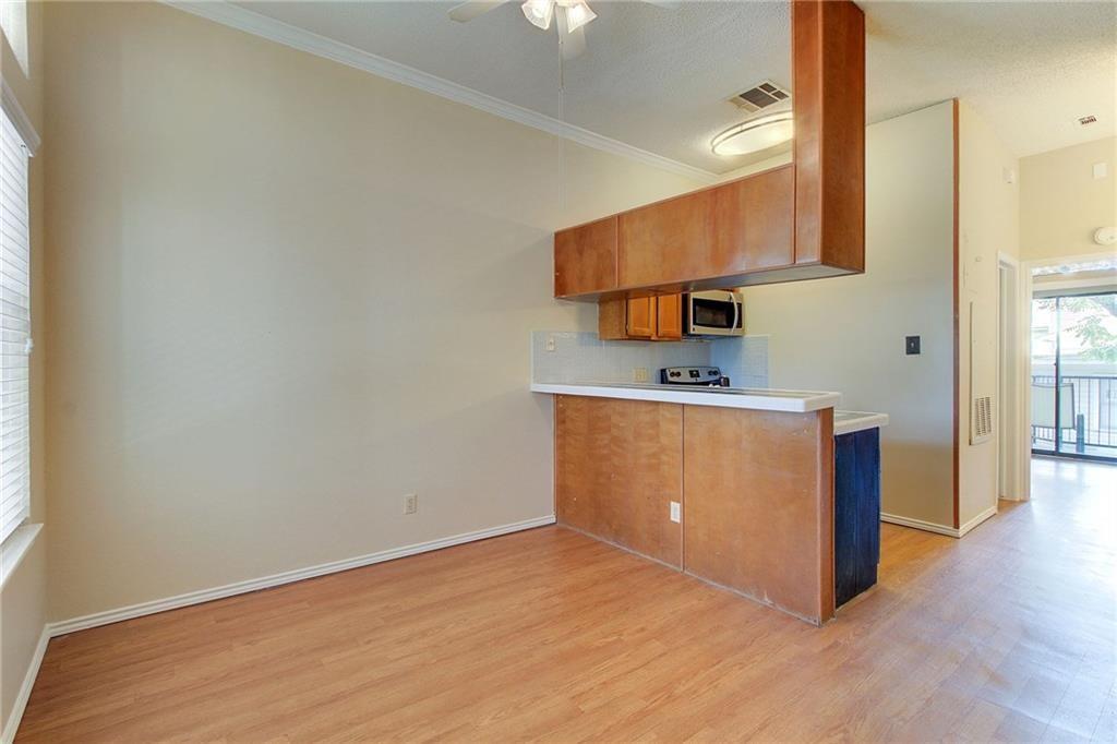 2802 Nueces Street, Unit 206 Austin, TX 78705 - Photo 4 of 14 a kitchen with stainless steel appliances a sink cabinets and a wooden floor