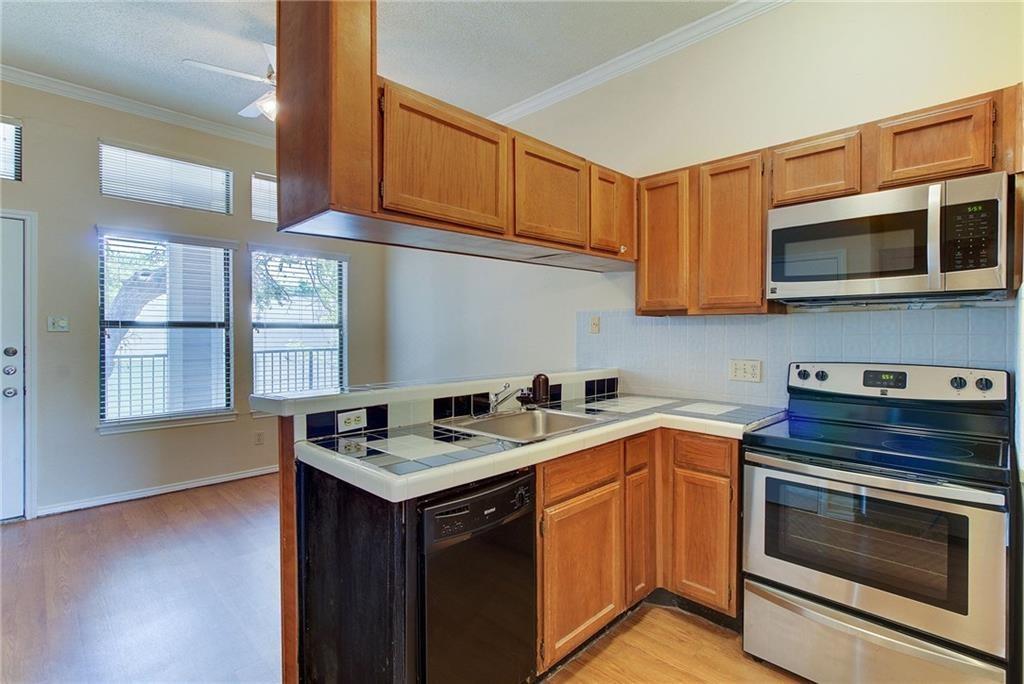 2802 Nueces Street, Unit 206 Austin, TX 78705 - Photo 7 of 14 a kitchen with stainless steel appliances a stove sink microwave and cabinets