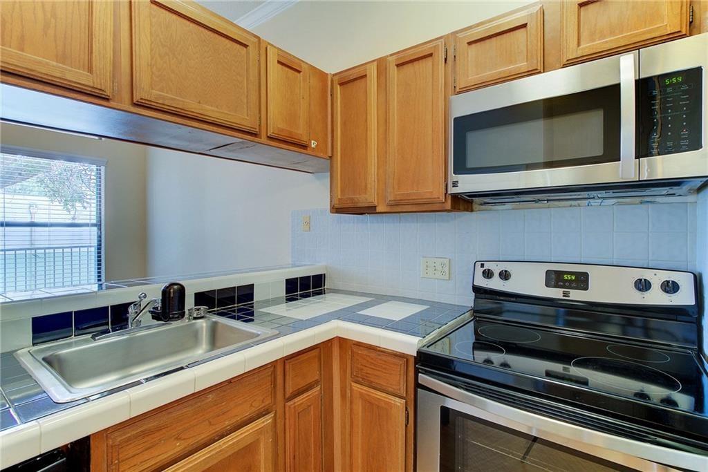 2802 Nueces Street, Unit 206 Austin, TX 78705 - Photo 8 of 14 a kitchen with stainless steel appliances granite countertop a sink stove and microwave