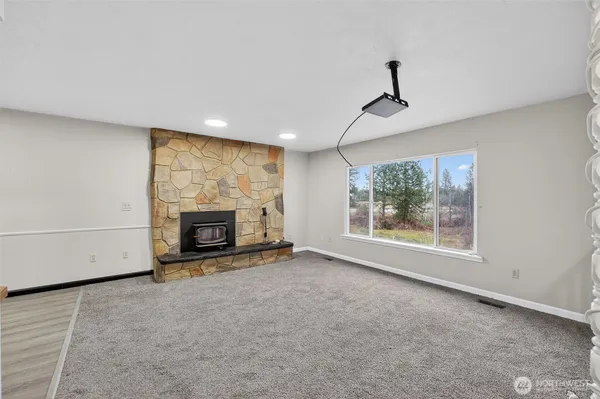 a view of an empty room with a fireplace and a window