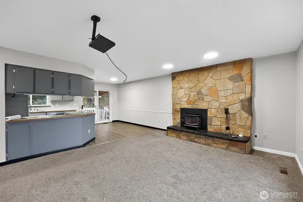 a large kitchen with stainless steel appliances wooden floor and a fireplace