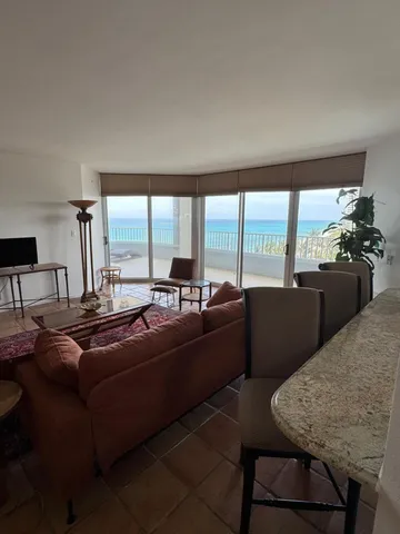 a living room with furniture and large windows