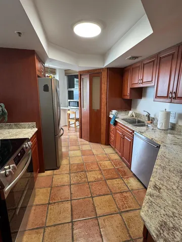 a kitchen with stainless steel appliances granite countertop a refrigerator a stove a sink and dishwasher