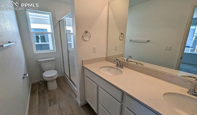 a bathroom with a granite countertop toilet a sink and a mirror