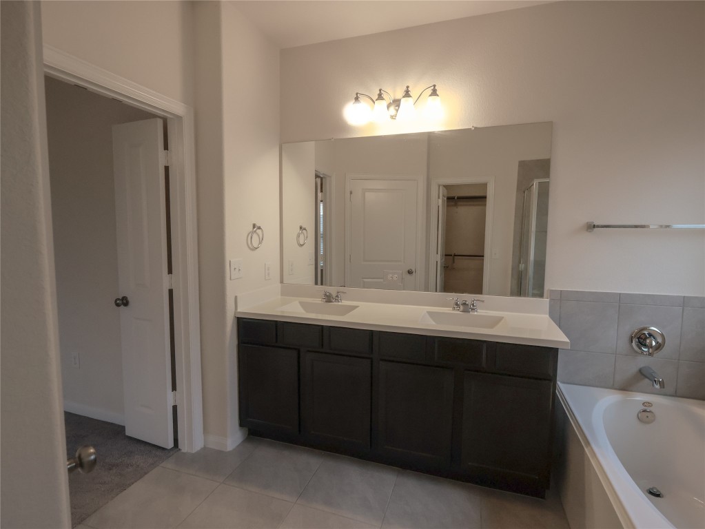 14008 Madrigal Lane Austin, TX 78660 - Photo 11 of 18 a bathroom with a tub sink and mirror