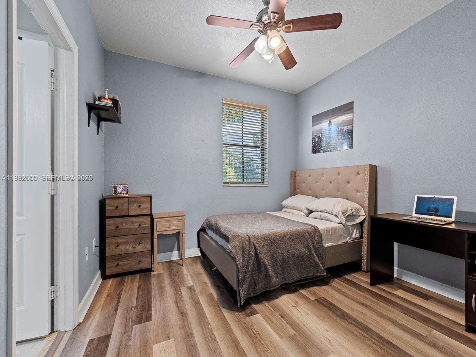 11279 Southwest 238th Street Homestead, FL 33032 - Photo 11 of 40 a bedroom with a bed and a chandelier