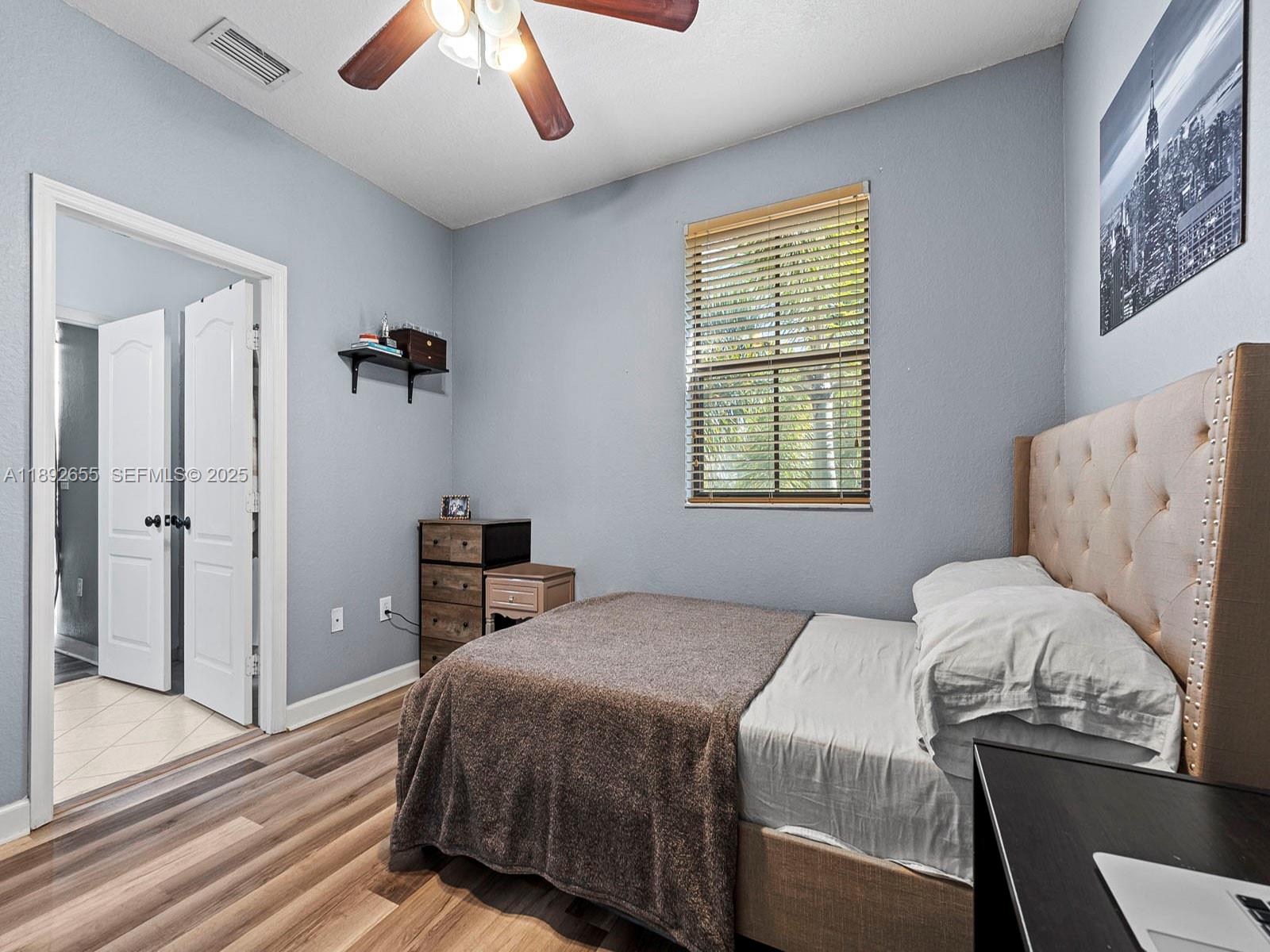 11279 Southwest 238th Street Homestead, FL 33032 - Photo 12 of 40 a bedroom with a bed and a chandelier