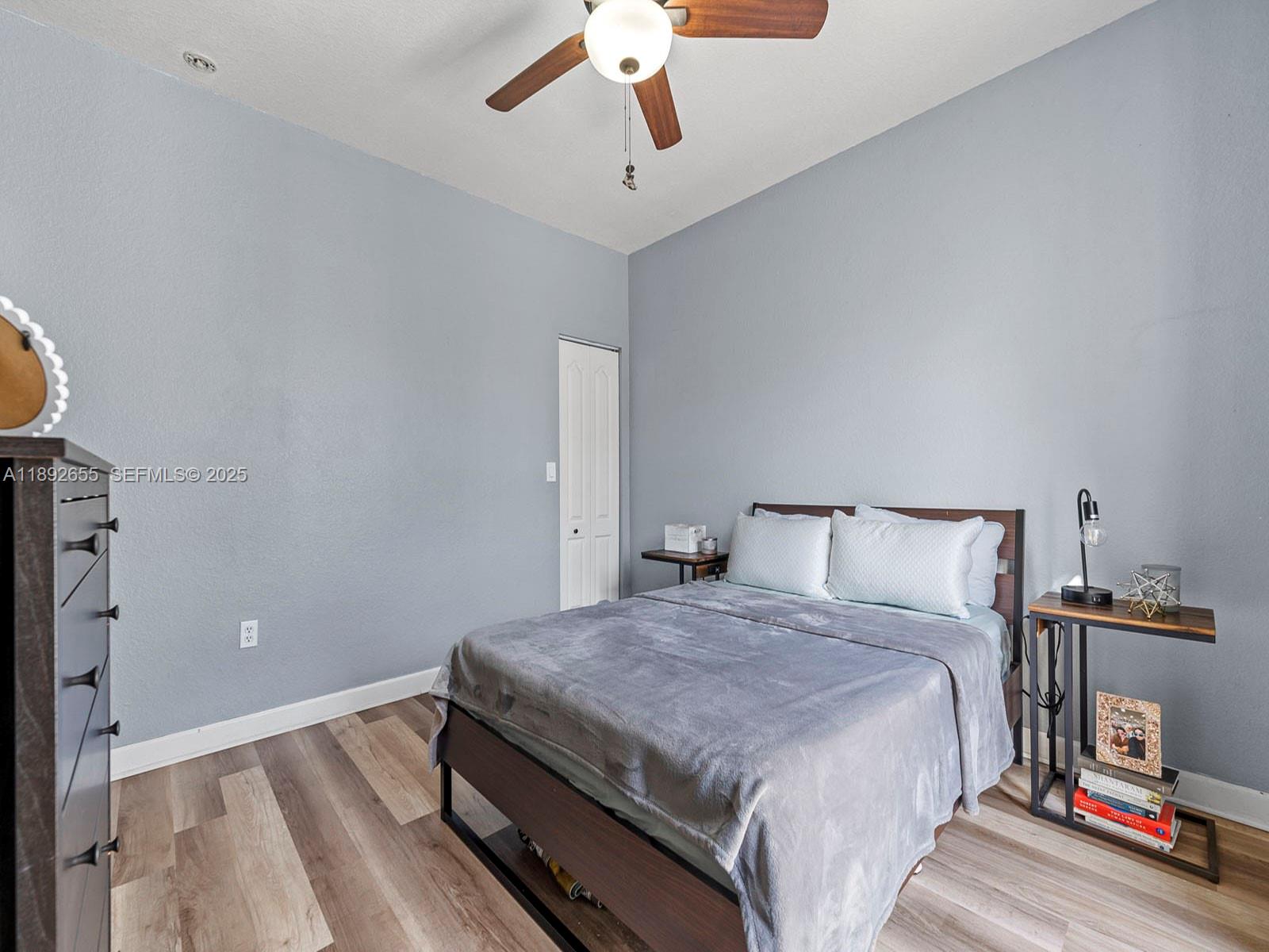 11279 Southwest 238th Street Homestead, FL 33032 - Photo 15 of 40 a bedroom with a bed and a chandelier