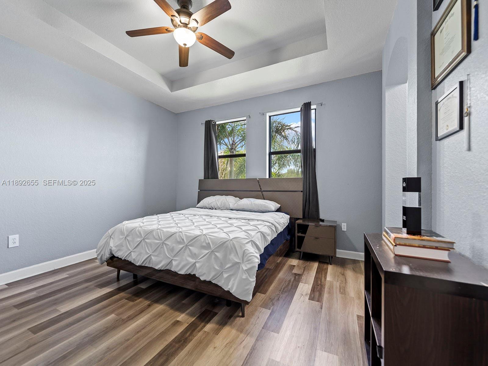 11279 Southwest 238th Street Homestead, FL 33032 - Photo 23 of 40 a bedroom with a bed and a chandelier