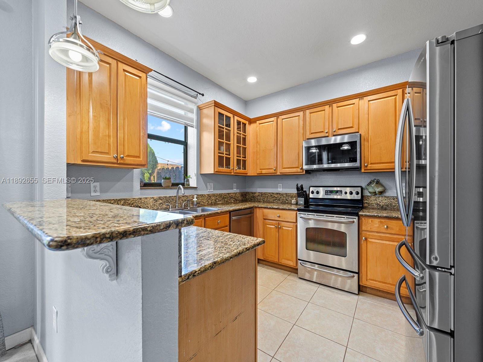 11279 Southwest 238th Street Homestead, FL 33032 - Photo 7 of 40 a kitchen with stainless steel appliances granite countertop a stove a sink and a microwave