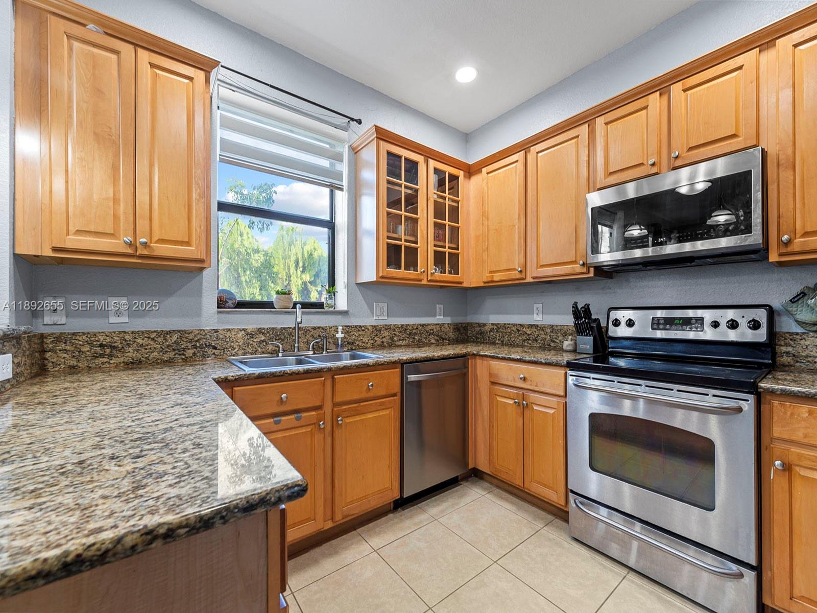 11279 Southwest 238th Street Homestead, FL 33032 - Photo 8 of 40 a kitchen with stainless steel appliances granite countertop a stove a sink and a microwave