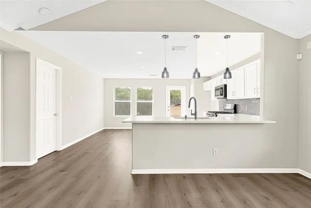 a view of a kitchen with wooden floor and a window