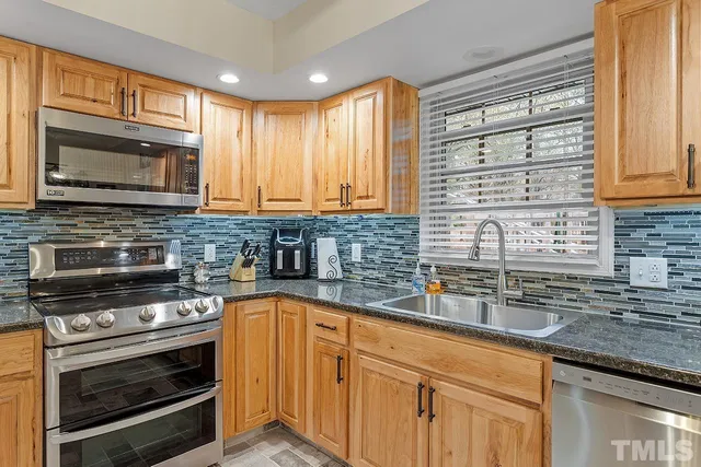 a kitchen with stainless steel appliances a stove sink and microwave