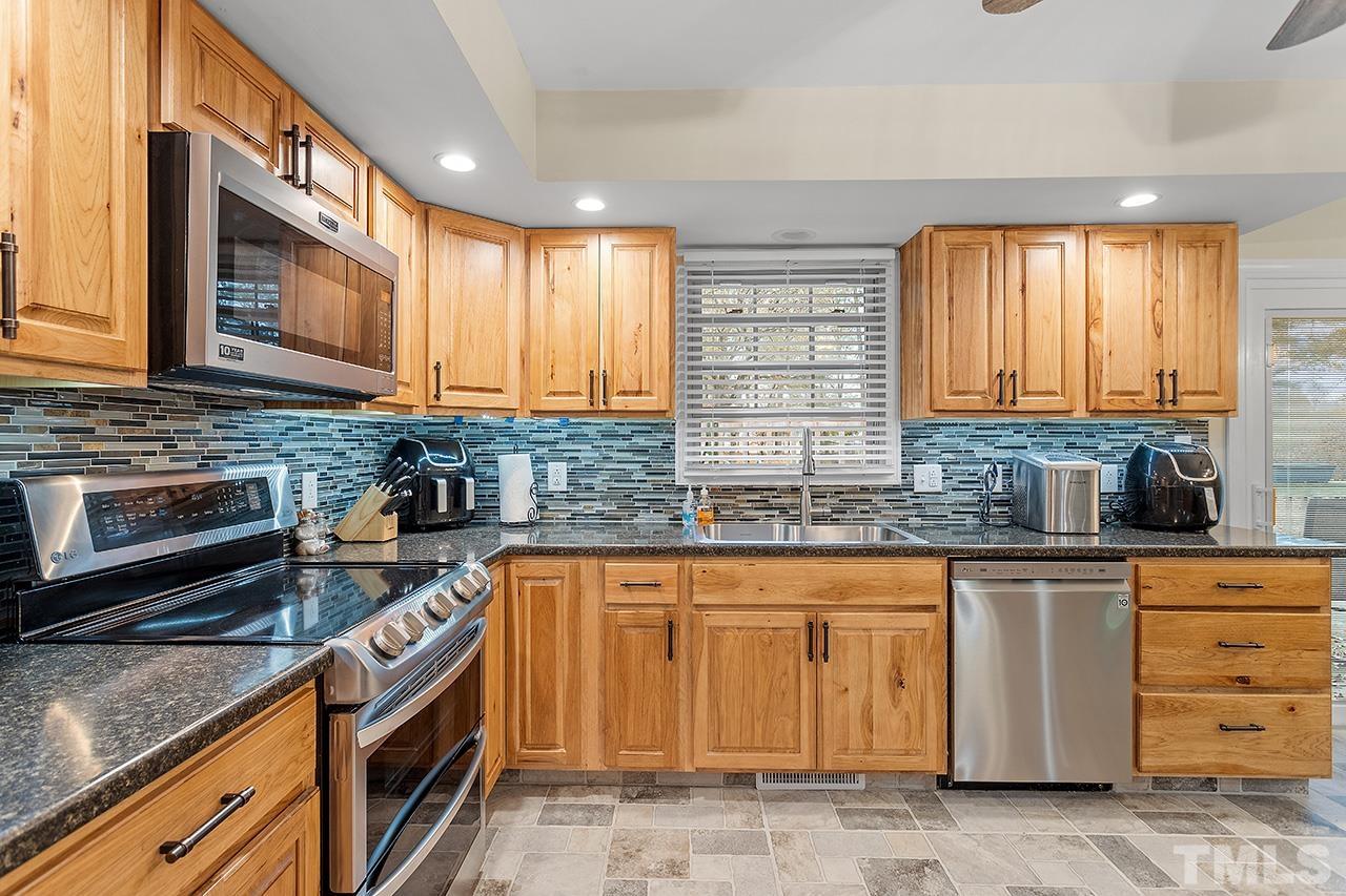 2683 C Rains Crossroads Road Selma, NC 27576 - Photo 14 of 30 a kitchen with stainless steel appliances granite countertop a stove a sink and a microwave