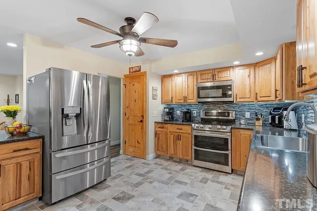 a kitchen with stainless steel appliances granite countertop a stove refrigerator and microwave