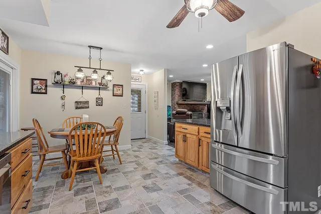 a kitchen with stainless steel appliances granite countertop a dining table and chairs