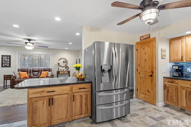 a kitchen with a refrigerator a sink cabinets and stainless steel appliances