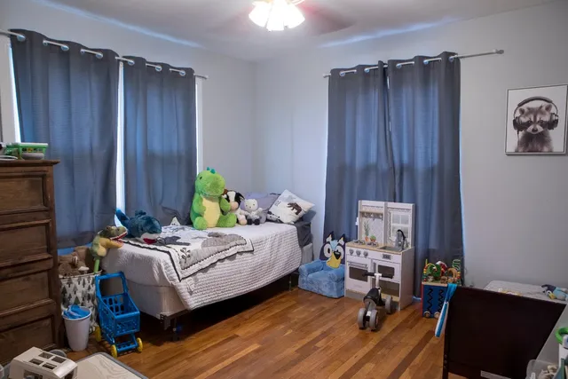 a bedroom with a bed and wooden floor