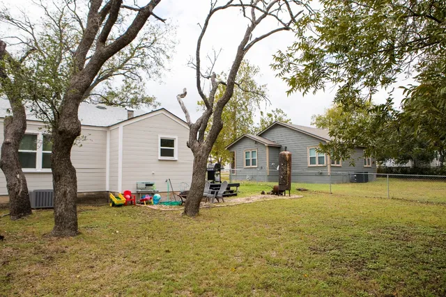 a view of a house with backyard and tree