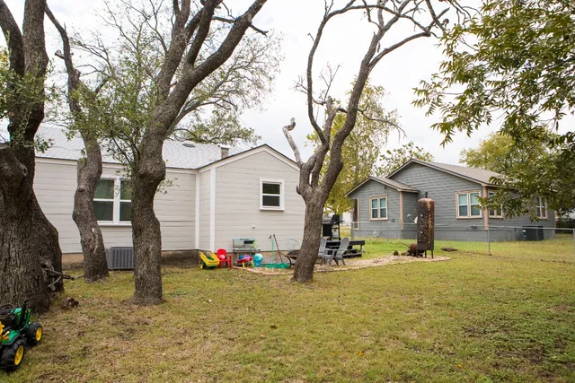 a view of a house with backyard and tree