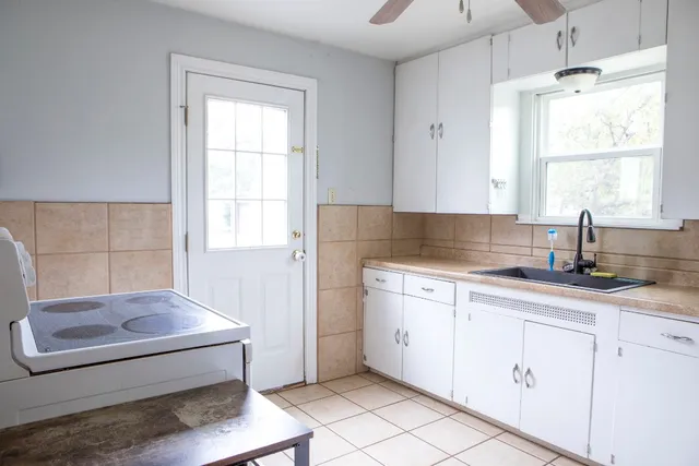 a kitchen with granite countertop white cabinets and a sink