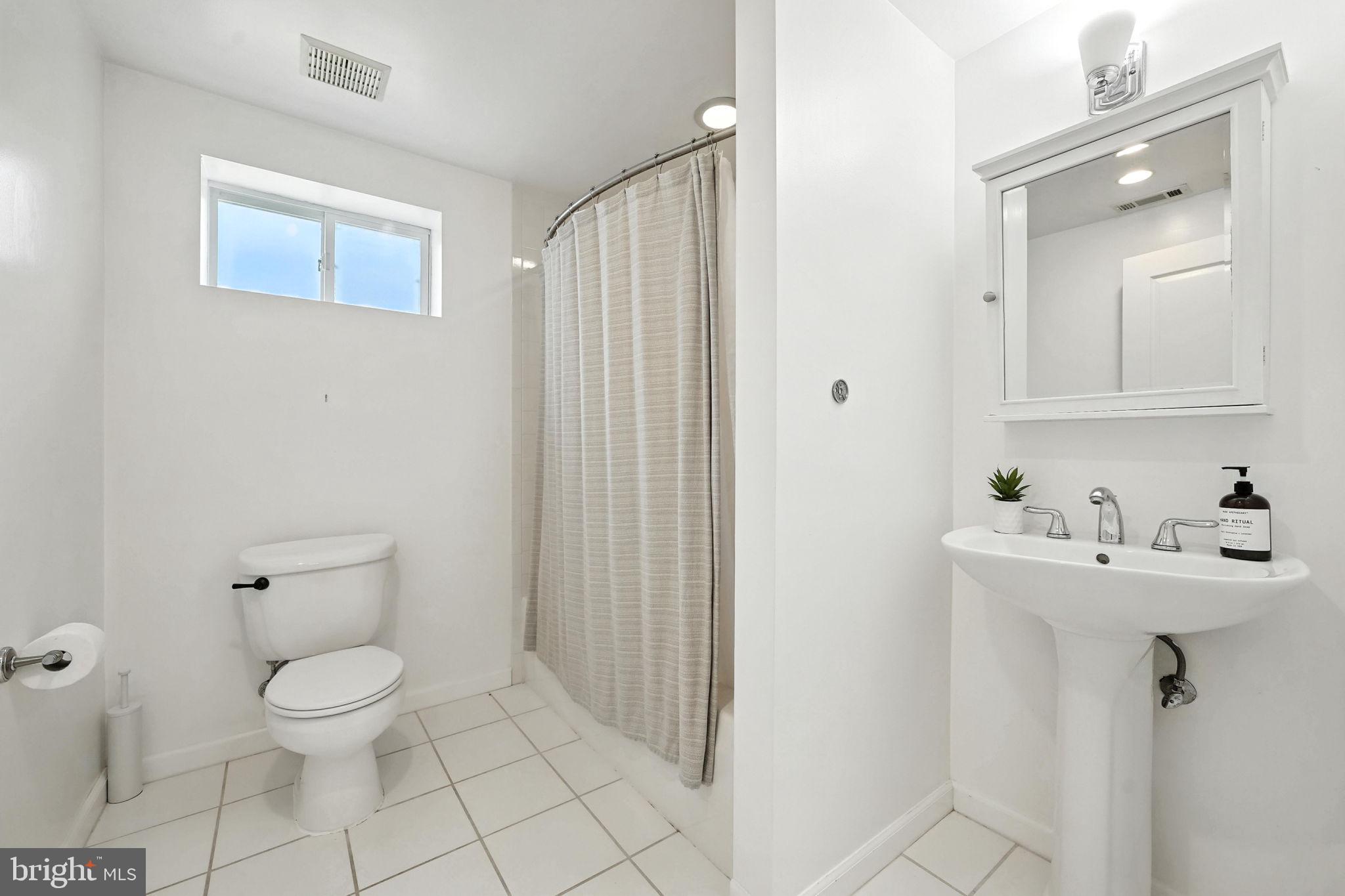 10002 Portland Place Silver Spring, MD 20901 - Photo 26 of 31 a bathroom with a toilet a sink and mirror