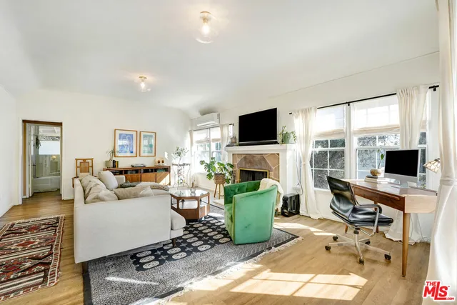 a living room with furniture a fireplace and a flat screen tv