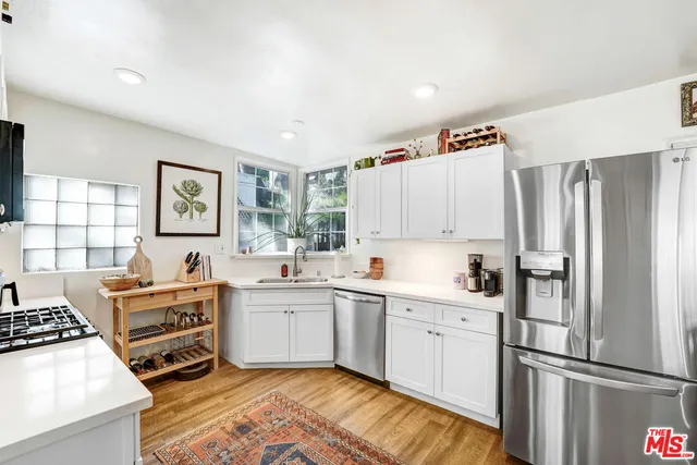 a kitchen with stainless steel appliances a refrigerator sink and cabinets