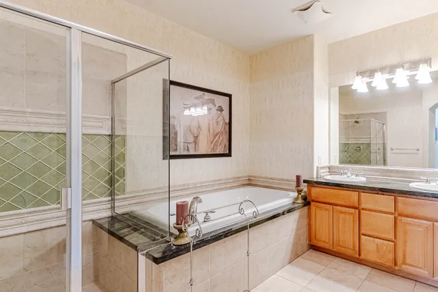 a bathroom with a tub sink and mirror