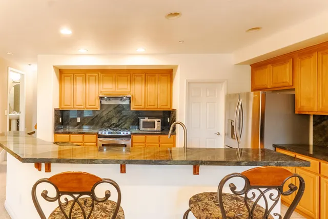 a kitchen with granite countertop a sink and cabinets
