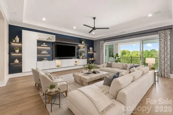 a living room with furniture a flat screen tv and a large window