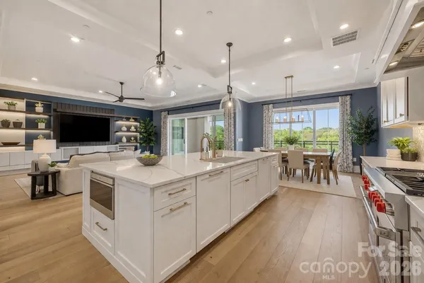 a kitchen with a stove a sink a microwave a dining table and chairs