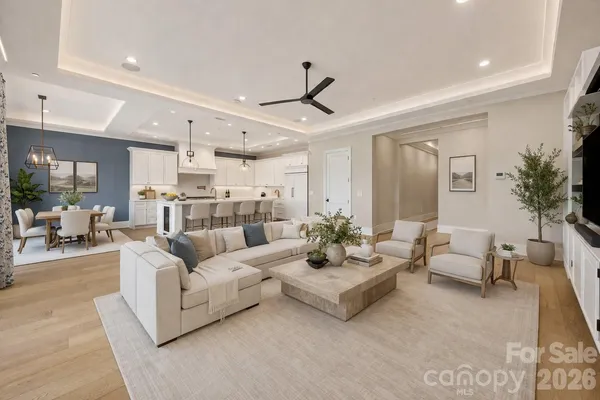 a living room with furniture white walls and a chandelier
