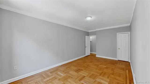 a view of a hallway with wooden floor and chandelier