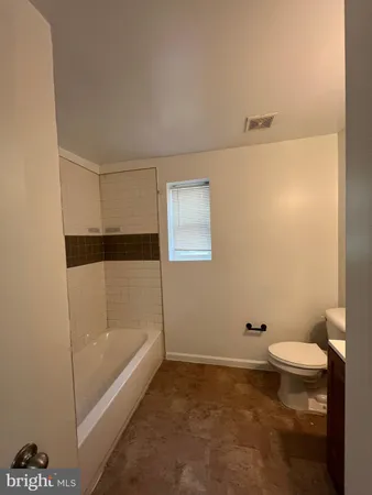 a bathroom with a granite countertop sink a toilet and bathtub