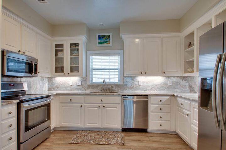 4587 Woodwind Drive Destin, FL 32541 - Photo 8 of 24 a kitchen with granite countertop cabinets stainless steel appliances and a window