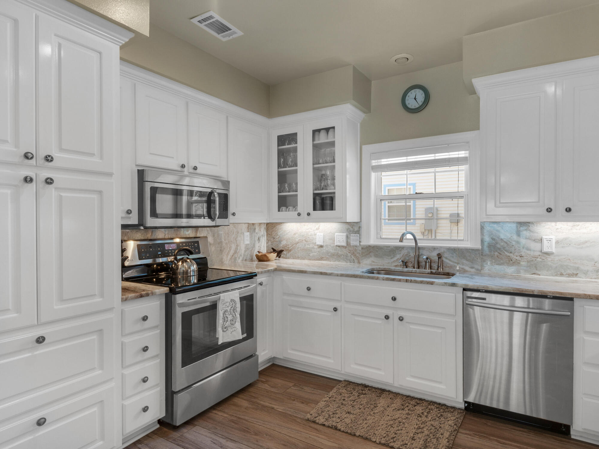 4587 Woodwind Drive Destin, FL 32541 - Photo 9 of 24 a kitchen with stainless steel appliances granite countertop a sink and cabinets with wooden floors