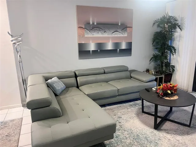 a living room with furniture and a potted plant