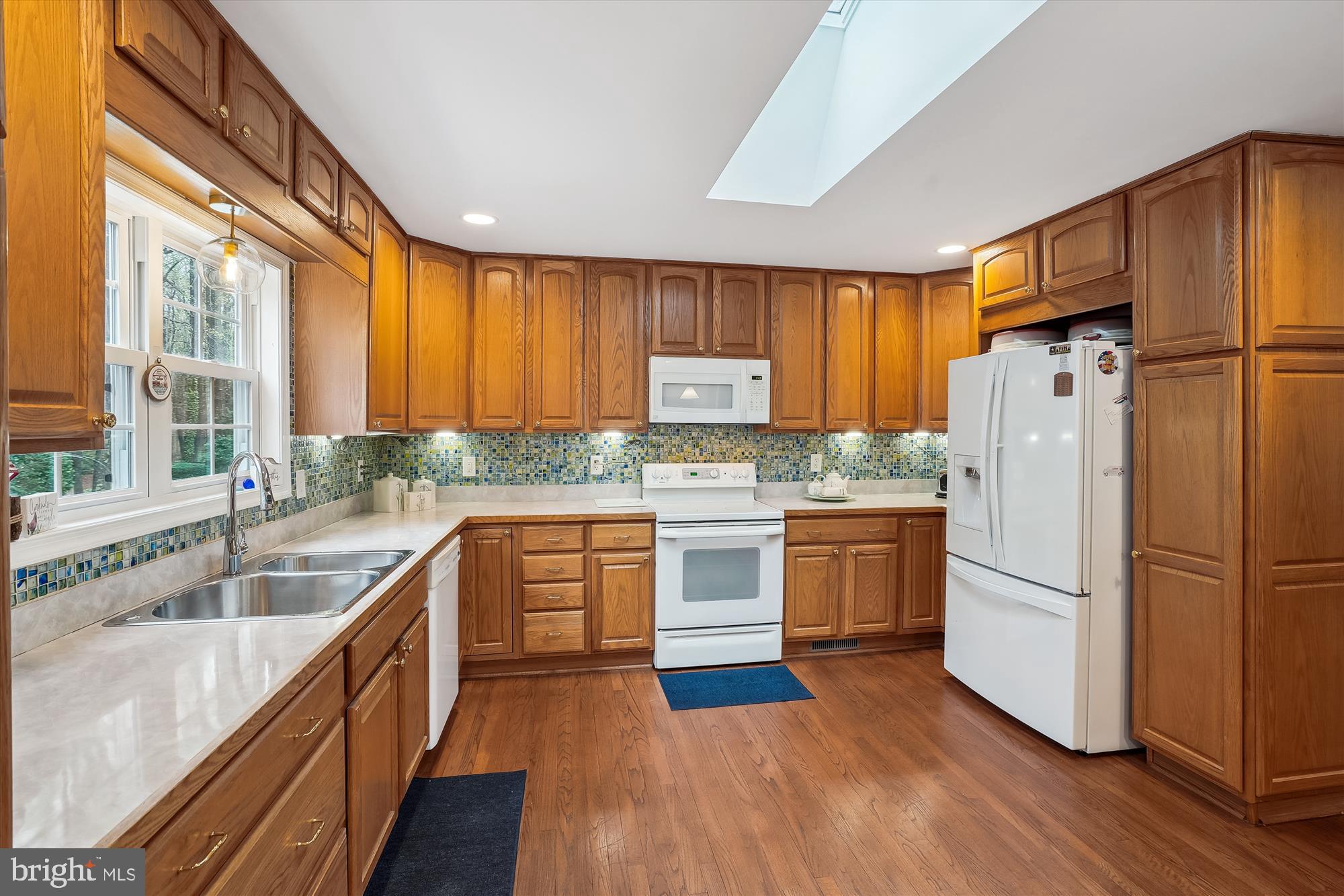 6957 Conservation Drive Springfield, VA 22153 - Photo 17 of 64 a kitchen with granite countertop wooden floors appliances and windows