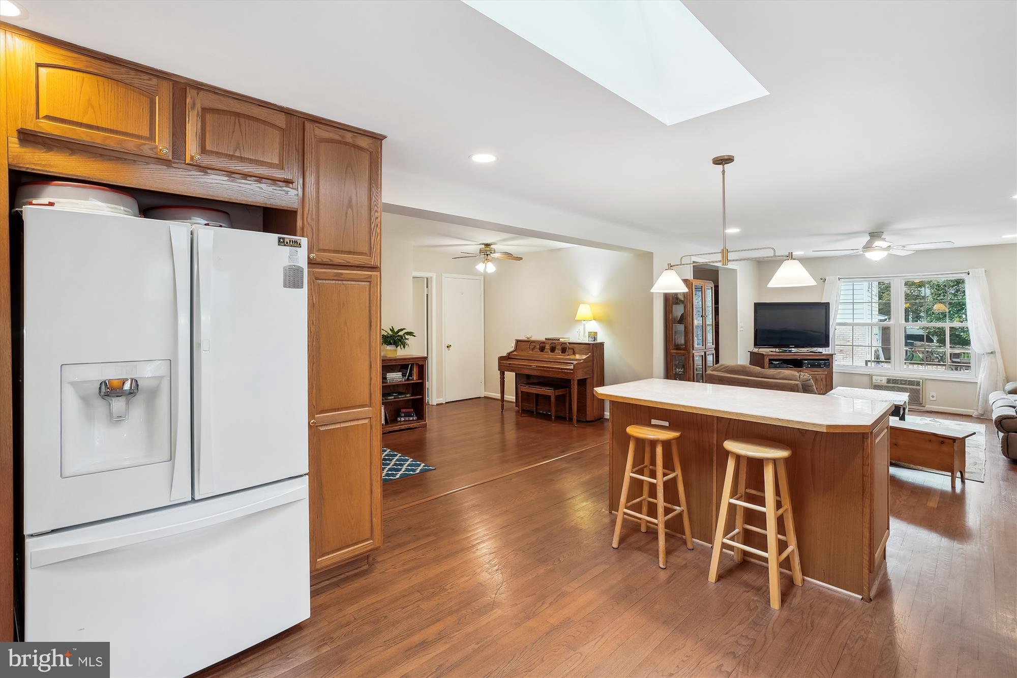 6957 Conservation Drive Springfield, VA 22153 - Photo 19 of 64 a kitchen with stainless steel appliances granite countertop a refrigerator a microwave a stove and a dining table with wooden floor