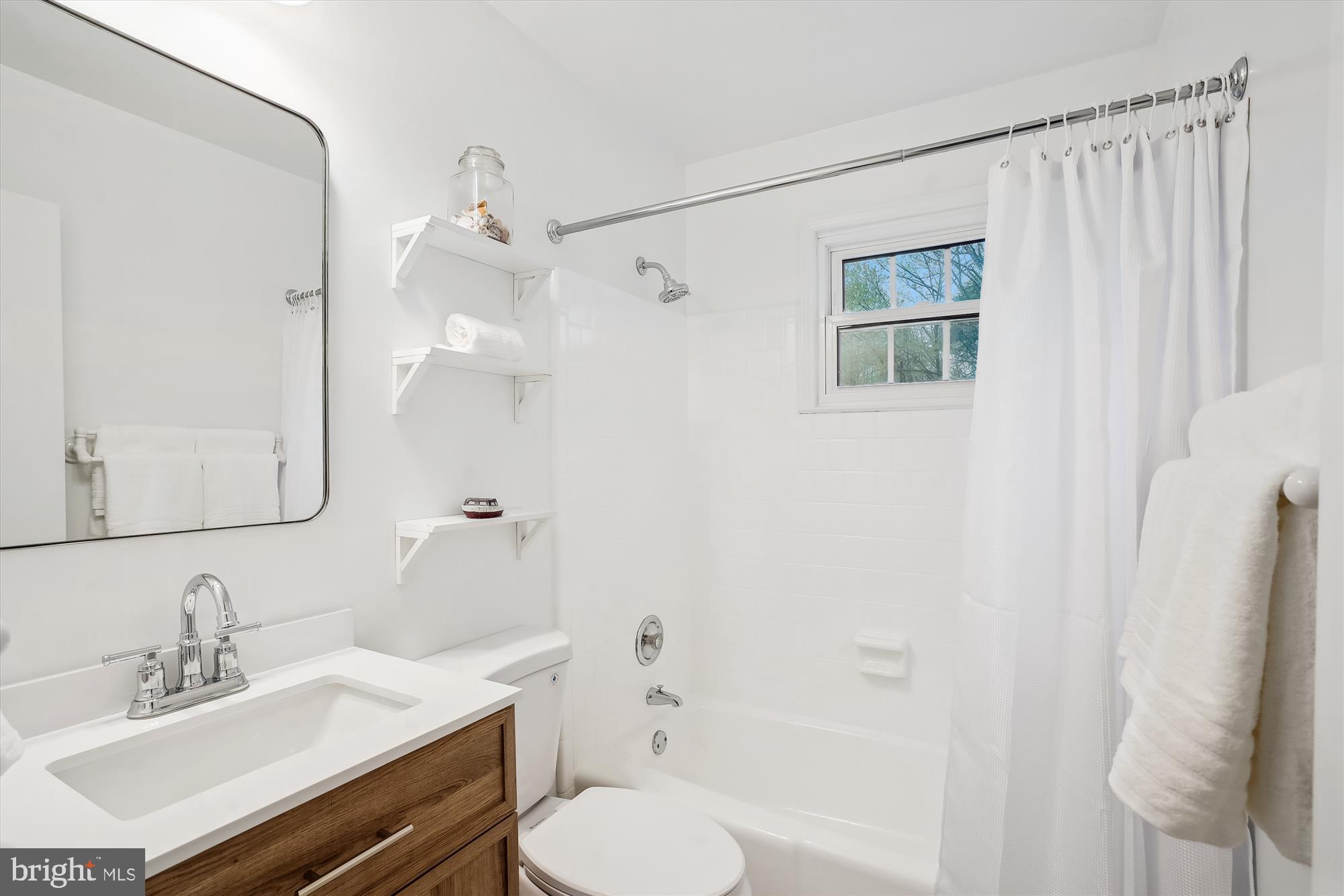 6957 Conservation Drive Springfield, VA 22153 - Photo 37 of 64 a bathroom with a sink toilet a mirror and shower