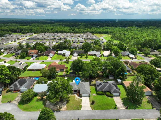 an aerial view of residential houses with outdoor space and trees