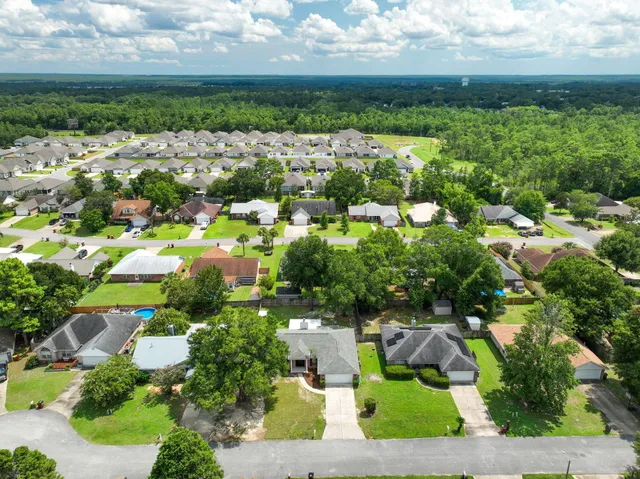 an aerial view of residential houses with outdoor space and trees