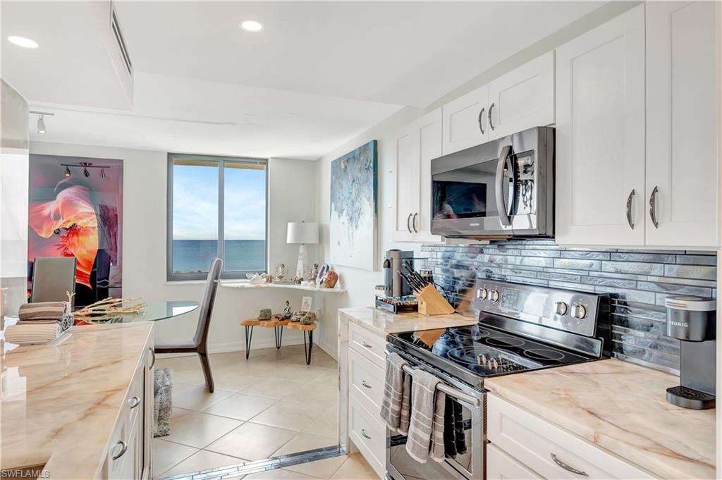 11 Bluebill Avenue, Unit 1101 Naples, FL 34108 - Photo 19 of 40 a kitchen with stainless steel appliances a stove a sink and a microwave