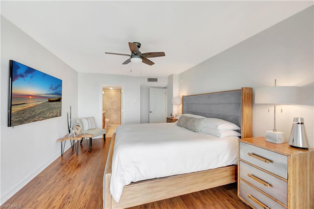 11 Bluebill Avenue, Unit 1101 Naples, FL 34108 - Photo 25 of 40 a bedroom with a bed and a flat screen tv