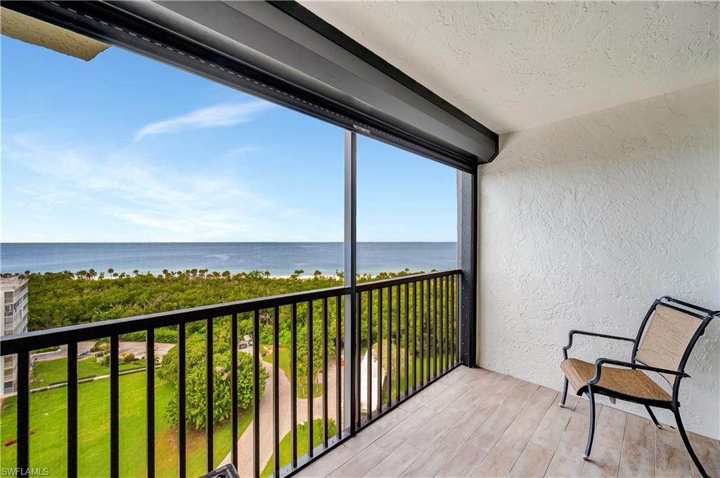 11 Bluebill Avenue, Unit 1101 Naples, FL 34108 - Photo 10 of 40 a view of a balcony with chair and wooden floor