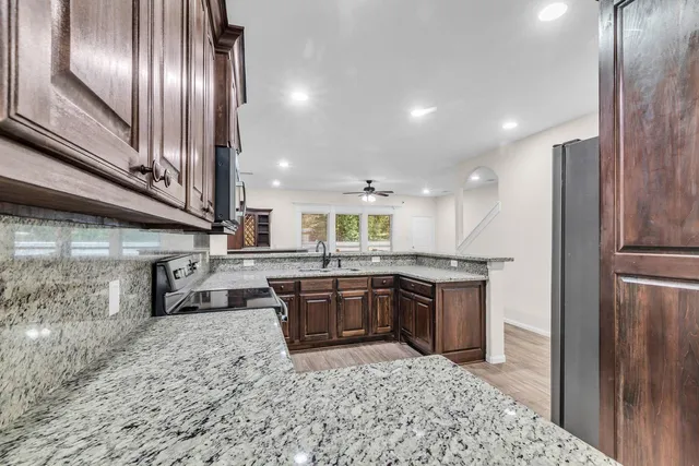 a kitchen with stainless steel appliances granite countertop lots of counter top space and wooden floor