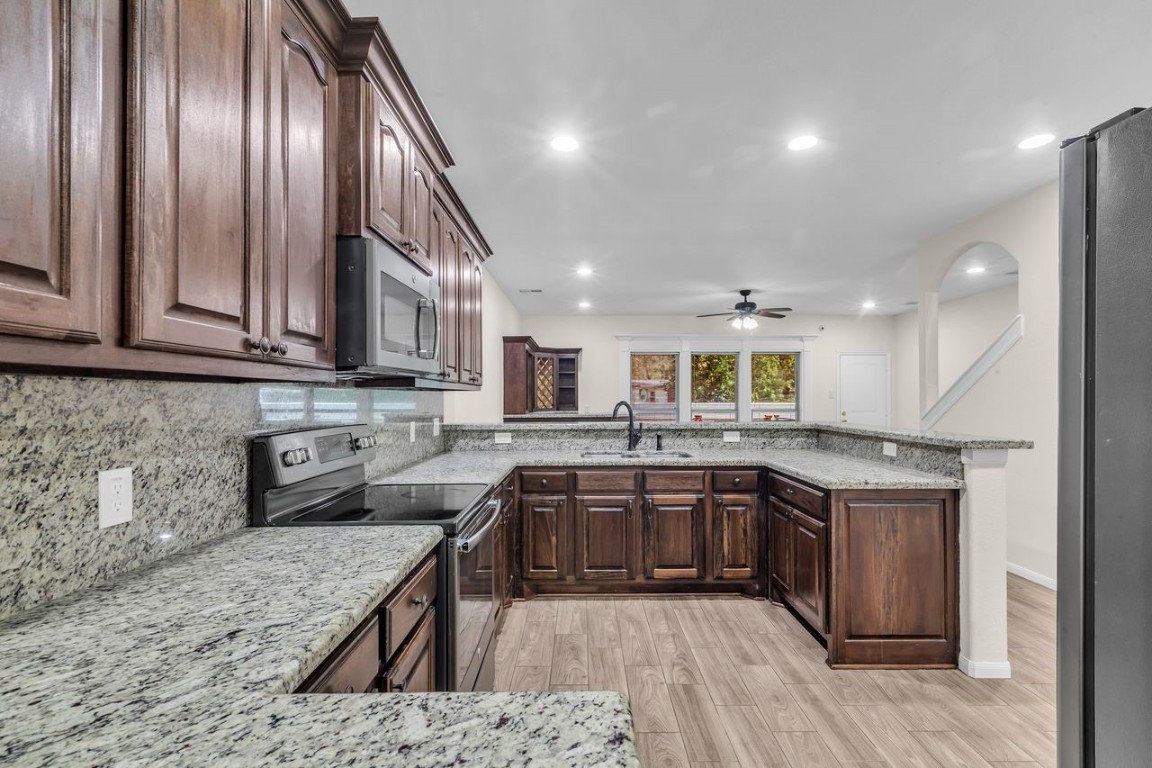 25171 Virginia Lane Porter, TX 77365 - Photo 12 of 39 a kitchen with stainless steel appliances granite countertop stove top oven a sink and dishwasher
