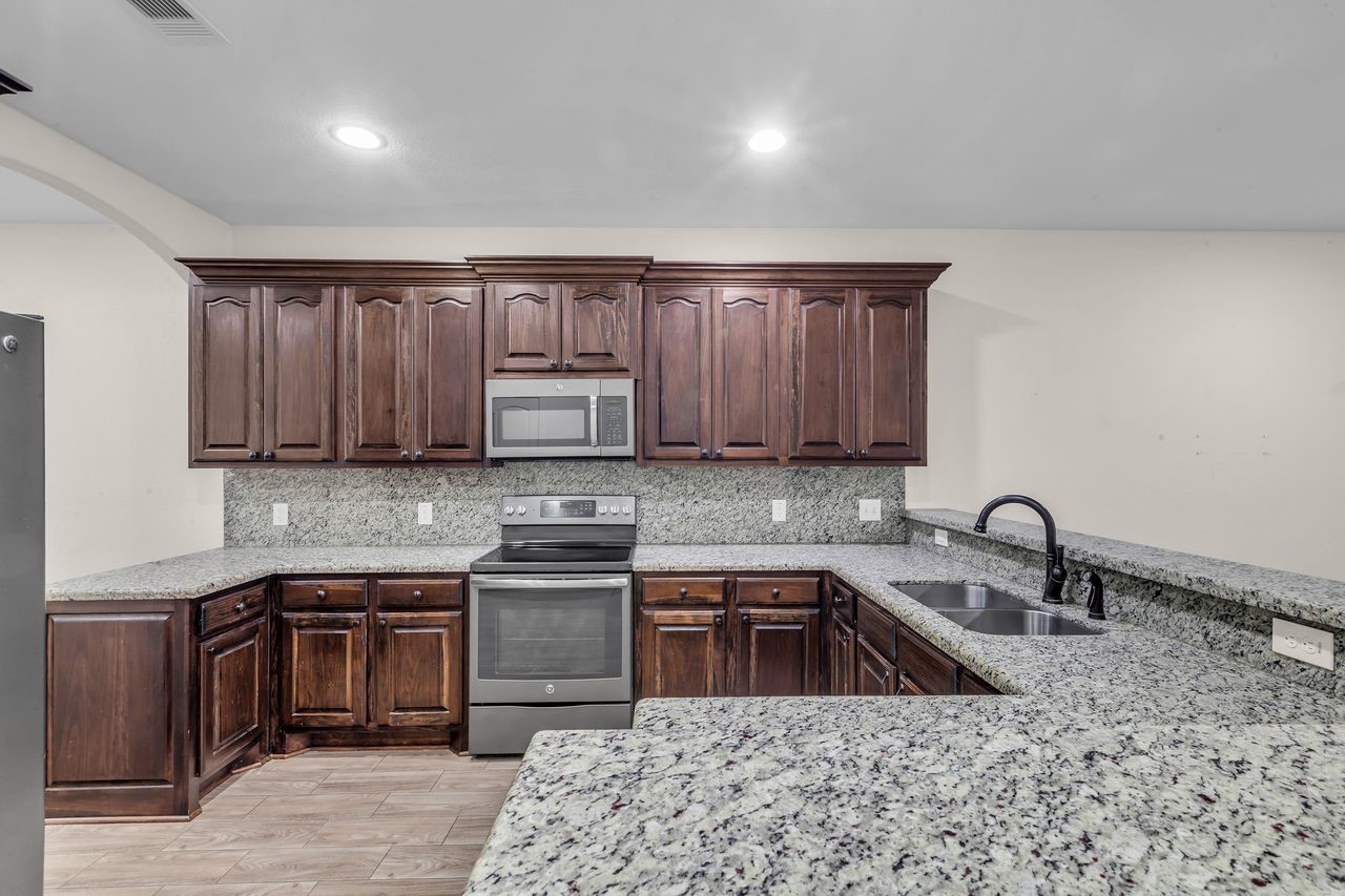 25171 Virginia Lane Porter, TX 77365 - Photo 13 of 39 a kitchen with stainless steel appliances granite countertop a sink stove and refrigerator