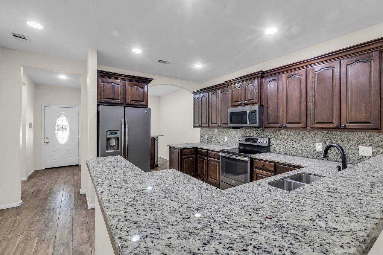 25171 Virginia Lane Porter, TX 77365 - Photo 14 of 39 a kitchen with stainless steel appliances granite countertop a sink refrigerator and cabinets